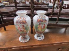 A pair of hand painted opaque glass vases