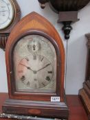 An arched top mahogany inlaid chiming mantel clock with silvered dial