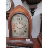 An arched top mahogany inlaid chiming mantel clock with silvered dial