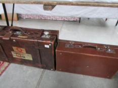 An early 20th century leather suitcase with labels and a faux leather suitcase