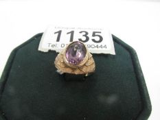 An amethyst set ring in textured gold mount,