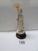 An ivory figure on base of a lady with parasol