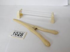 A pair of ivory glove stretchers and one other item