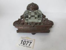 A 1920's cast metal inkstand with glass inkwell