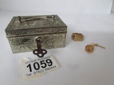 A gold ring and a gold tie tack in an old Chinese metal jewellery box with key