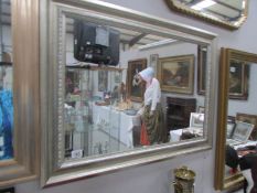 A wall mirror in silver coloured frame