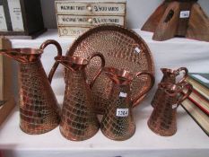 A graduated set of 5 early 20th century crocodile skin effect copper jugs with Neptune mark (Joseph