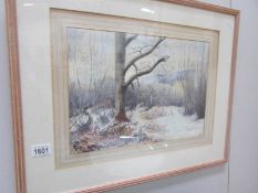 A framed and glazed watercolour winter forest scene initialled J W