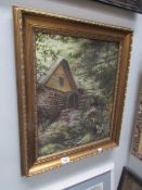 A gilt framed watermill scene