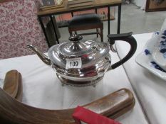 A silver plate tea pot on stand