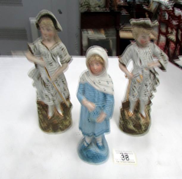 A pair of continental bisque figures and one other