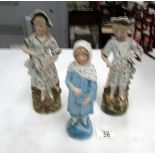 A pair of continental bisque figures and one other