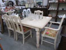 A large painted dining table and 6 chairs