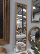 A tall gilt framed mirror