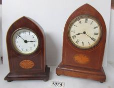 An arched top mantel clock with shell inlay and a smaller example