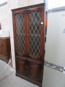 An oak lead glazed corner cabinet