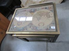 A nest of 3 brass mounted table with map inset tops