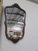 A mahogany framed shield shaped mirror