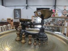 A set of kitchen scales with brass pans and brass weights