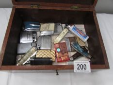 A wooden box containing lighters and pen knives