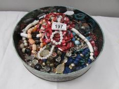 A tin of costume jewellery,