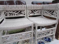 A pair of painted wicker corner chairs