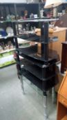 2 black and a clear glass television stands