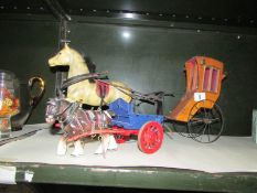 A toy horse pulling and hansom cab and one other