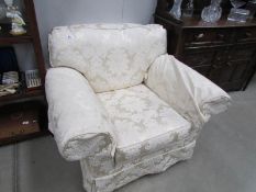 A cream brocade arm chair