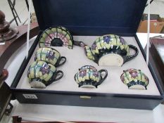 A cased Moorcroft tea for two set comprising teapot, sugar bowl, milk jug,