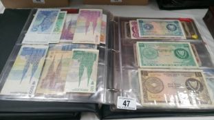 A folder of approximately 100 world bank notes,