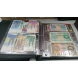 A folder of approximately 100 world bank notes,