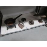 A cast iron skillet pan, a set of brass weights, a pestle & mortar,
