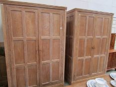 A pair of limed oak wardrobes together with a limed oak headboard