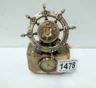 A brass nautical ship's wheel with clock face