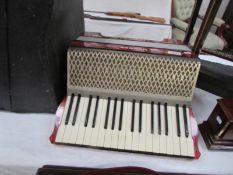 A cased Hohner piano accordion with old music