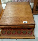 An oak coin cabinet with 4 drawers of various sets of pennies and half pennies