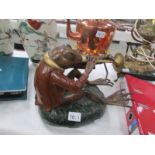 A cold painted bronze of a seated toad playing a woodwind instrument