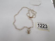 A pearl necklace with 18ct gold clasp and pendant drop