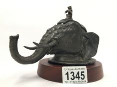 A circa 19th/20th century inkwell in the form of an elephant head with musician monkey finial