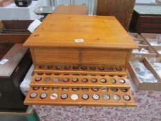 A Pine coin cabinet with 11 drawers full of various machine tokens