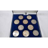 A case of 10 world silver coins (crown size)
