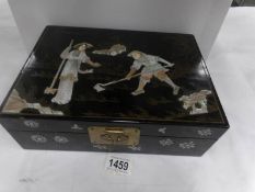 A Chinese lacquered jewellery box with gold and silver decoration and mother of pearl figure
