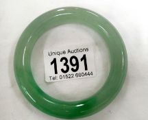 A Chinese apple green with dark green inclusions jadeite bangle