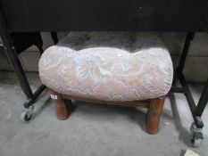 An upholstered stool with oak feet