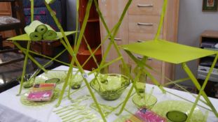 A green metal garden table with 2 chairs and a quantity of green picnic ware