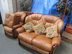 A wood framed tan leather 3 piece suite with matching stool