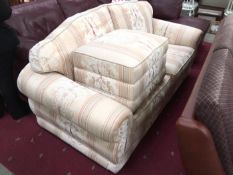 A cream patterned 2 seater sofa and pouffe