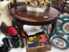 A dark wood stained round coffee table with Queen Anne legs