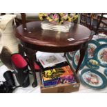 A dark wood stained round coffee table with Queen Anne legs